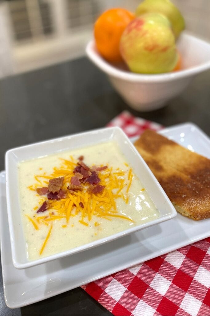 country potato soup with cheese and bacon sprinkled on top served with cornbread