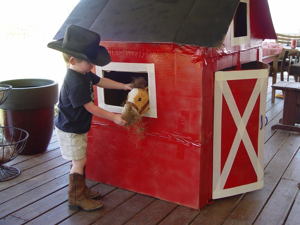 matt petting his horse in the cardboard box barn
