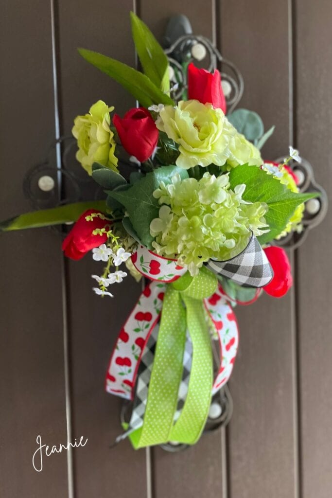 metal cross decorated with spring flowers and green bow