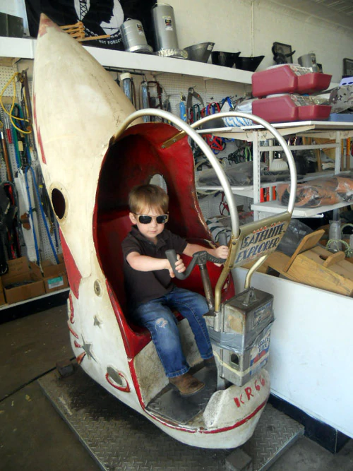 matt on the satellite explorer rocket ship kiddy ride at the feed and seed store