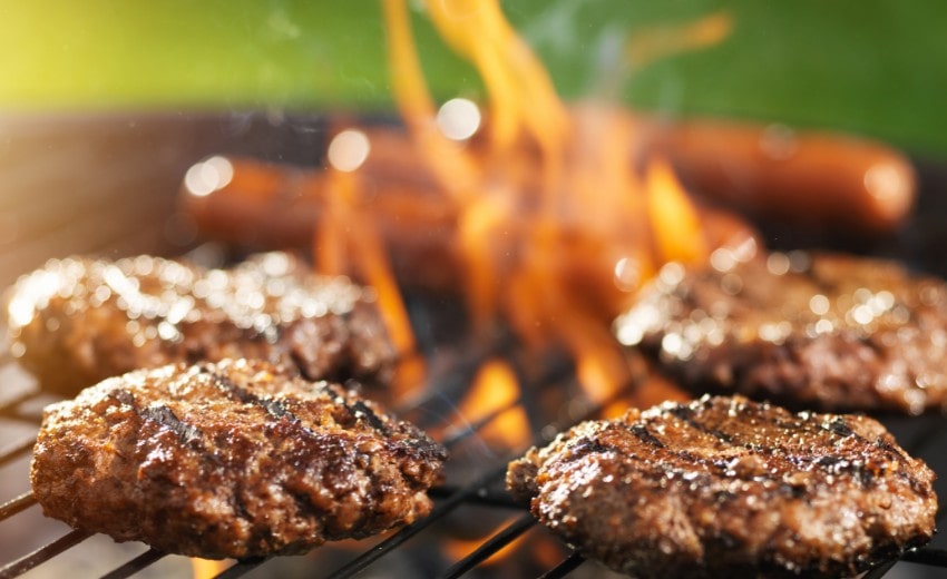 hamburgers cooking on a grill