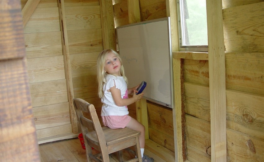 maggie playing school in the playhouse