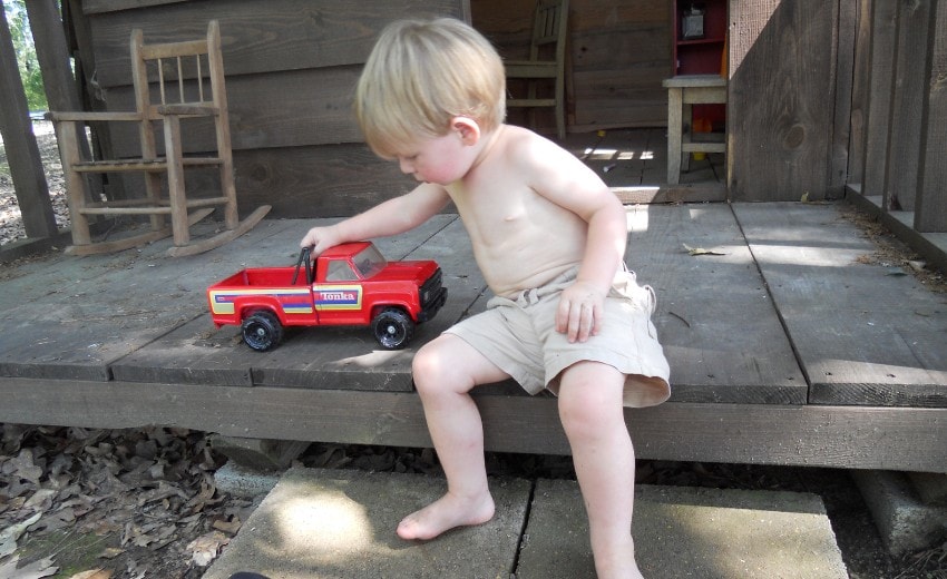 matt and a tonka truck on the porch of the playhouse