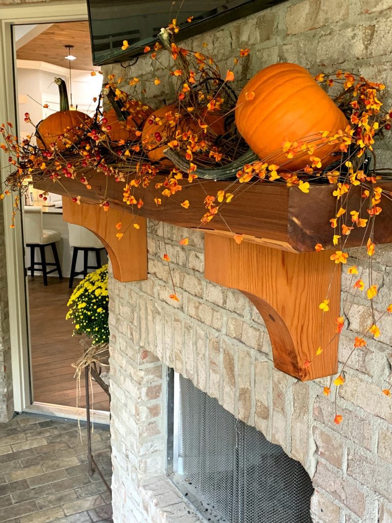 back porch mantel decorated for fall with pumpkins and bittersweet