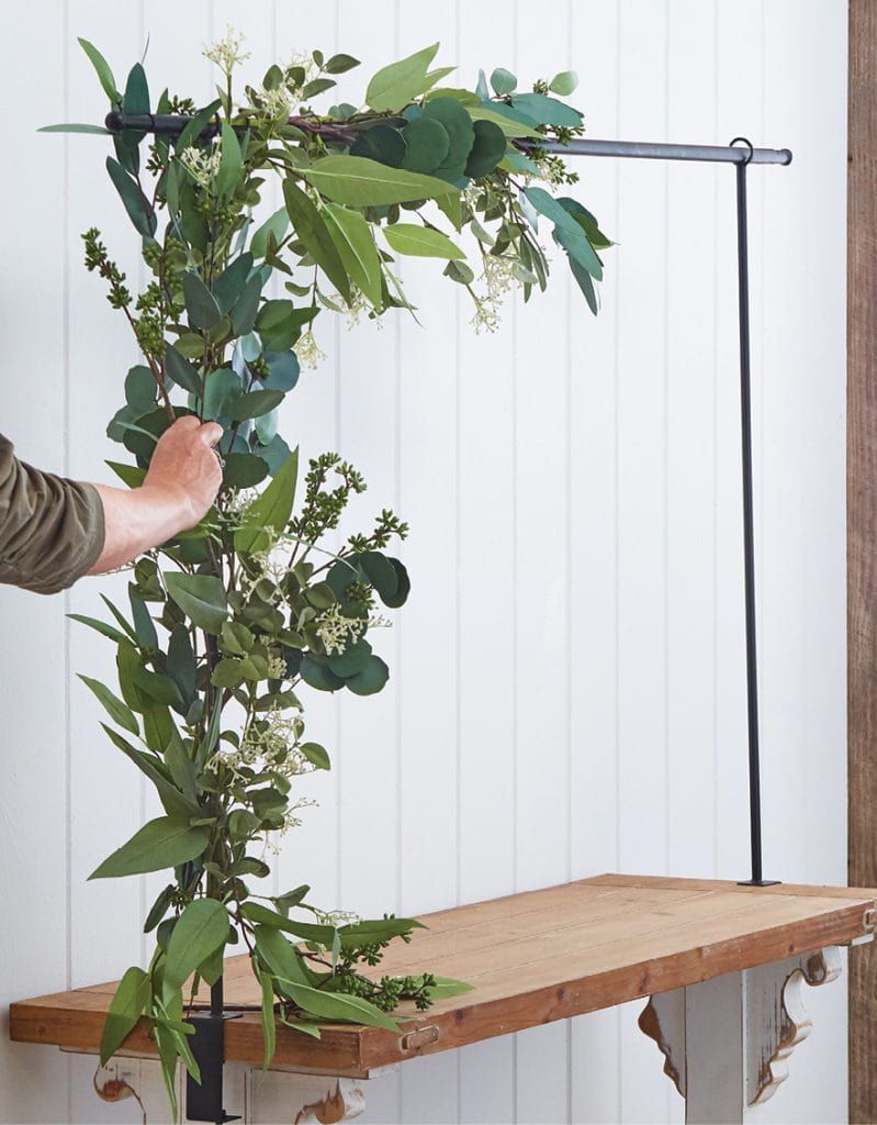how to decorate the over the table rod, star with greenery garland first