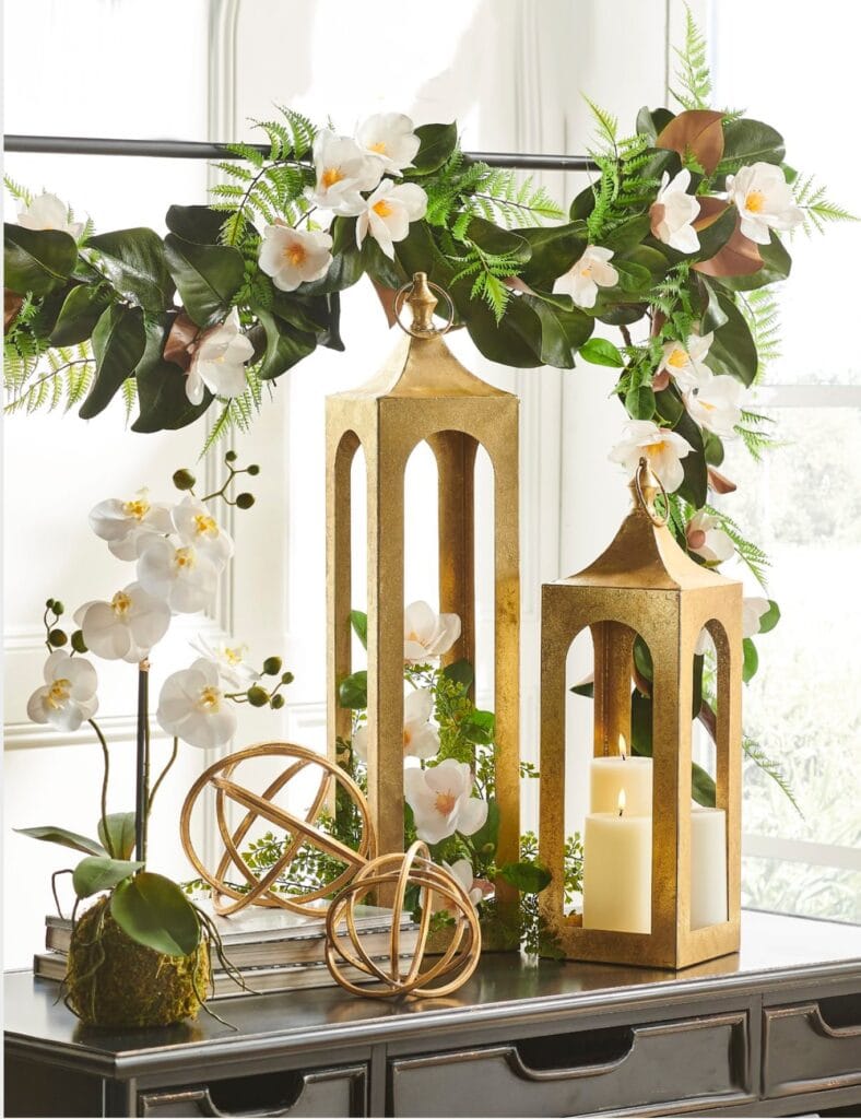 gold lanterns, orchids and magnolia garland with blooms on an over the table rod