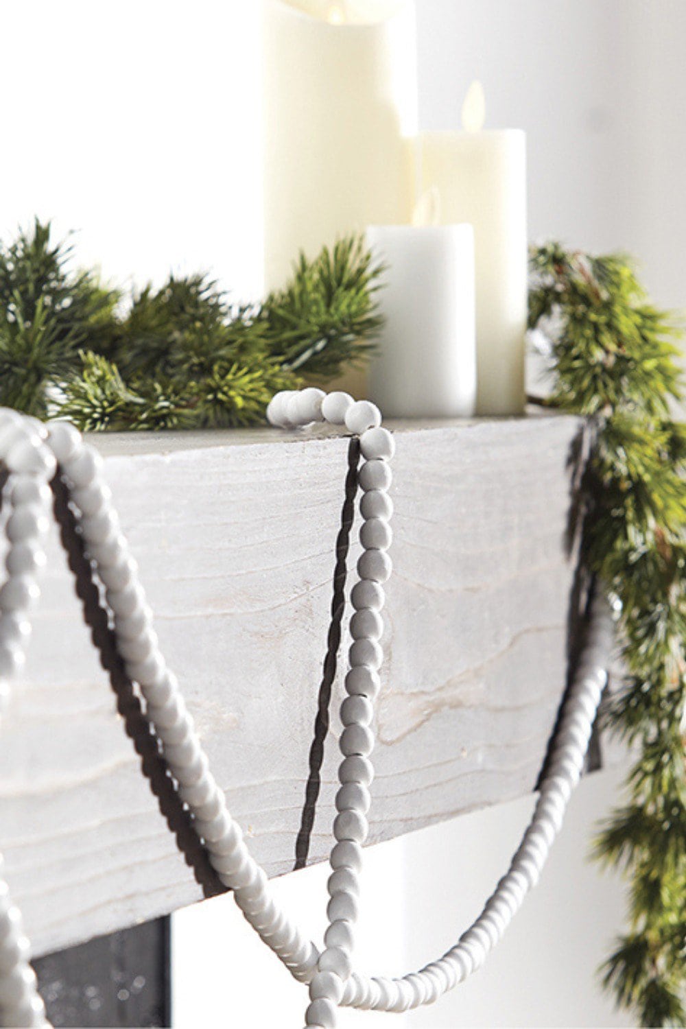 white wood bead garland on a mantel