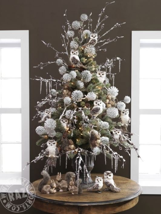 tabletop tree with white and brown feathered owls, woodland animal ornaments, big frosted ball picks and icy branches