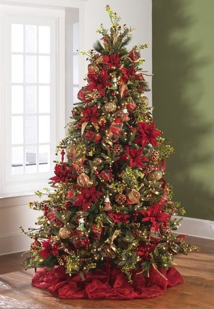 red velvet poinsettias, gold and red ball ornaments, ornate embellished glass ornaments on a green tree with a red tree skirt