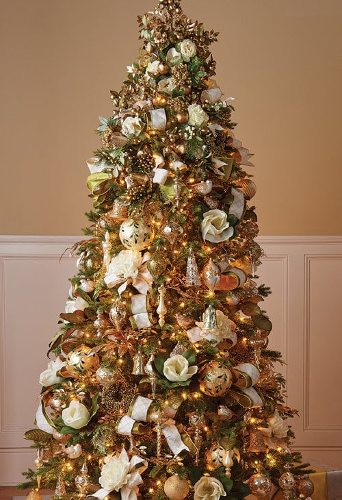gold glistening christmas tree, decked in gold ornaments and ball picks, creamy flowers, magnolias, gold pinecones, finials and kismets