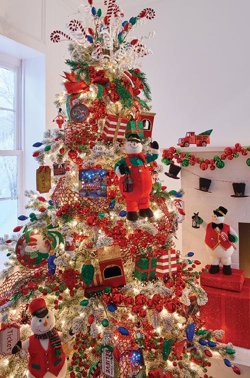 santa express tree with a train theme similar to the polar express, conductor snowmen, train tickets, train ornaments, red, green, blue decorations, ball garlands and black top hats.