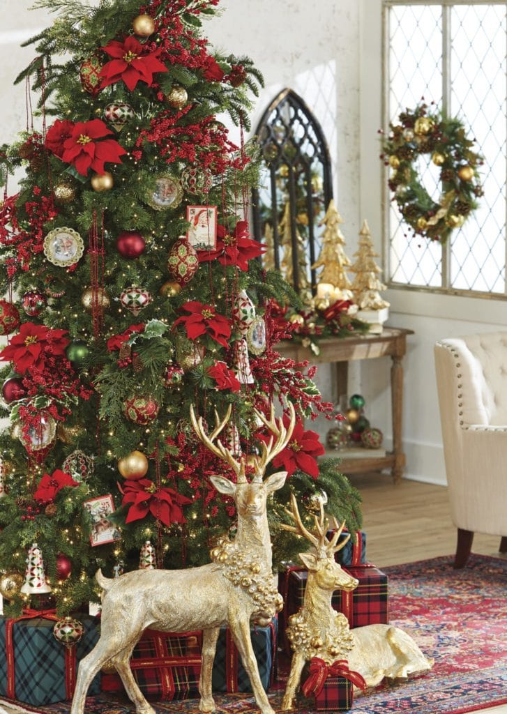 classic christmas tree with big red poinsettias, red berry sprays, gold, red and green, ornaments.