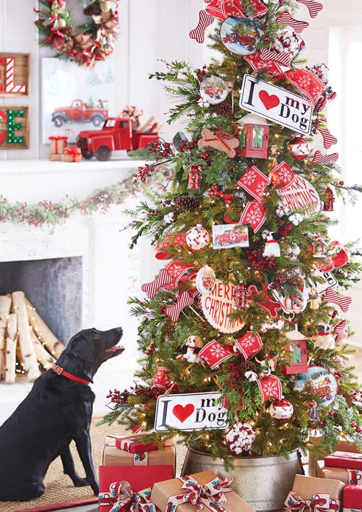 dog theme christmas tree with old red truck and tractor ornaments, dog ornament, red snowflake ribbon, i love my dog tags, pinecones and red berries