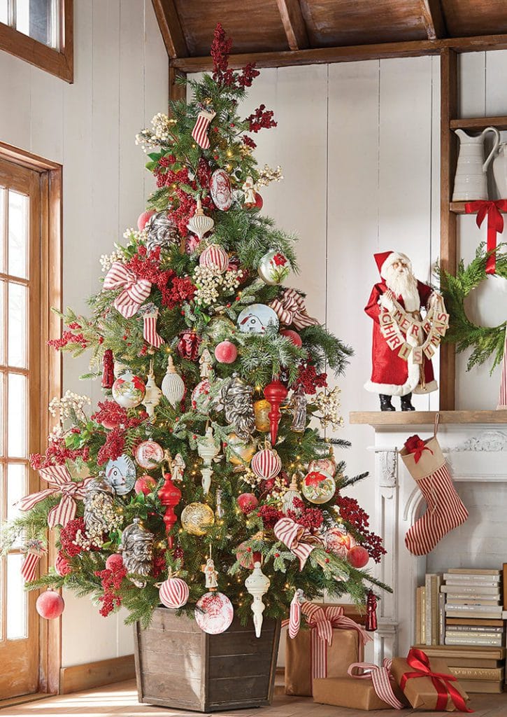potted christmas tree with red and white ticking style ribbon, cream berry sprays, red wooden finials, old fashioned santa faces, fabric ball ornaments