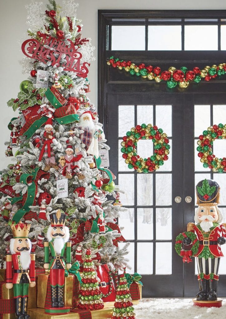 white flocked christmas tree with nutcrackers, elves, red and green ribbon, red green and gold ball garlands, 