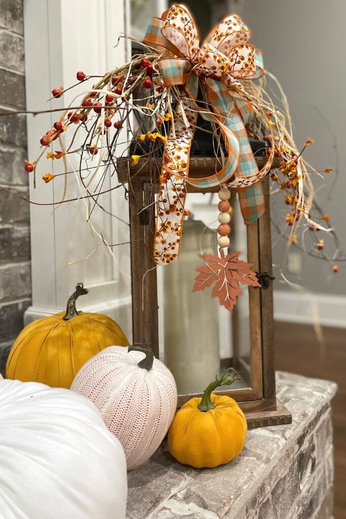 fall lantern topper with bittersweet, orange berries and a bow