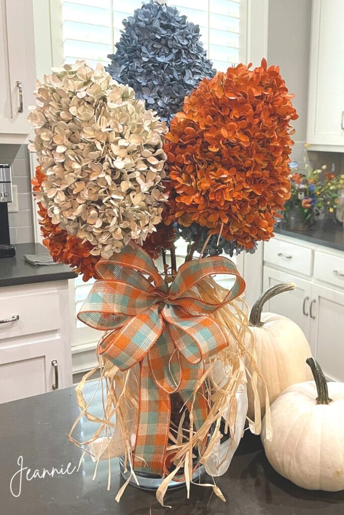 fall floral arrangement of dried hydrangeas painted cream, blue, and orange