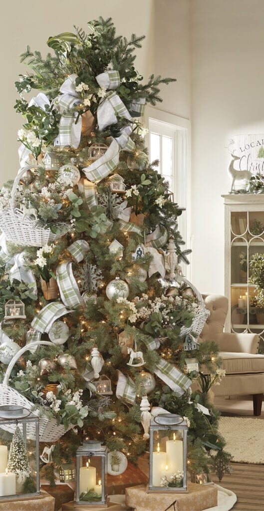holiday homestead christmas tree with sage green and white ornaments, double stacked ribbon in plaids and solids, creamy white ornaments, pale green eucalyptus sprays, cream berry picks, candle lanterns