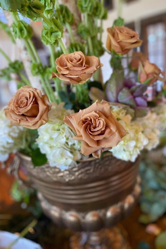 toffee roses in an urn with bells of ireland