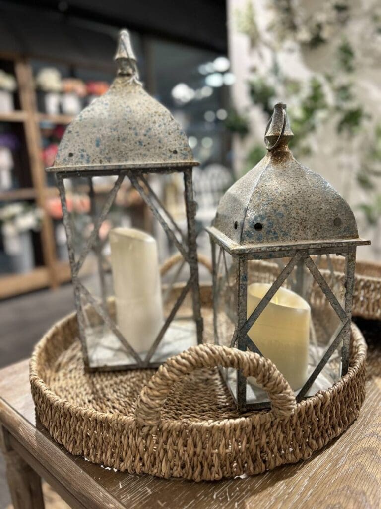 distressed metal lanterns in a wicker tray