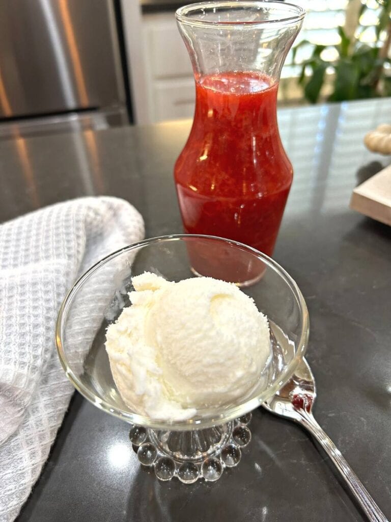 ice cream dish that belonged to my grandmother filled with vanilla ice cream and strawberry sauce