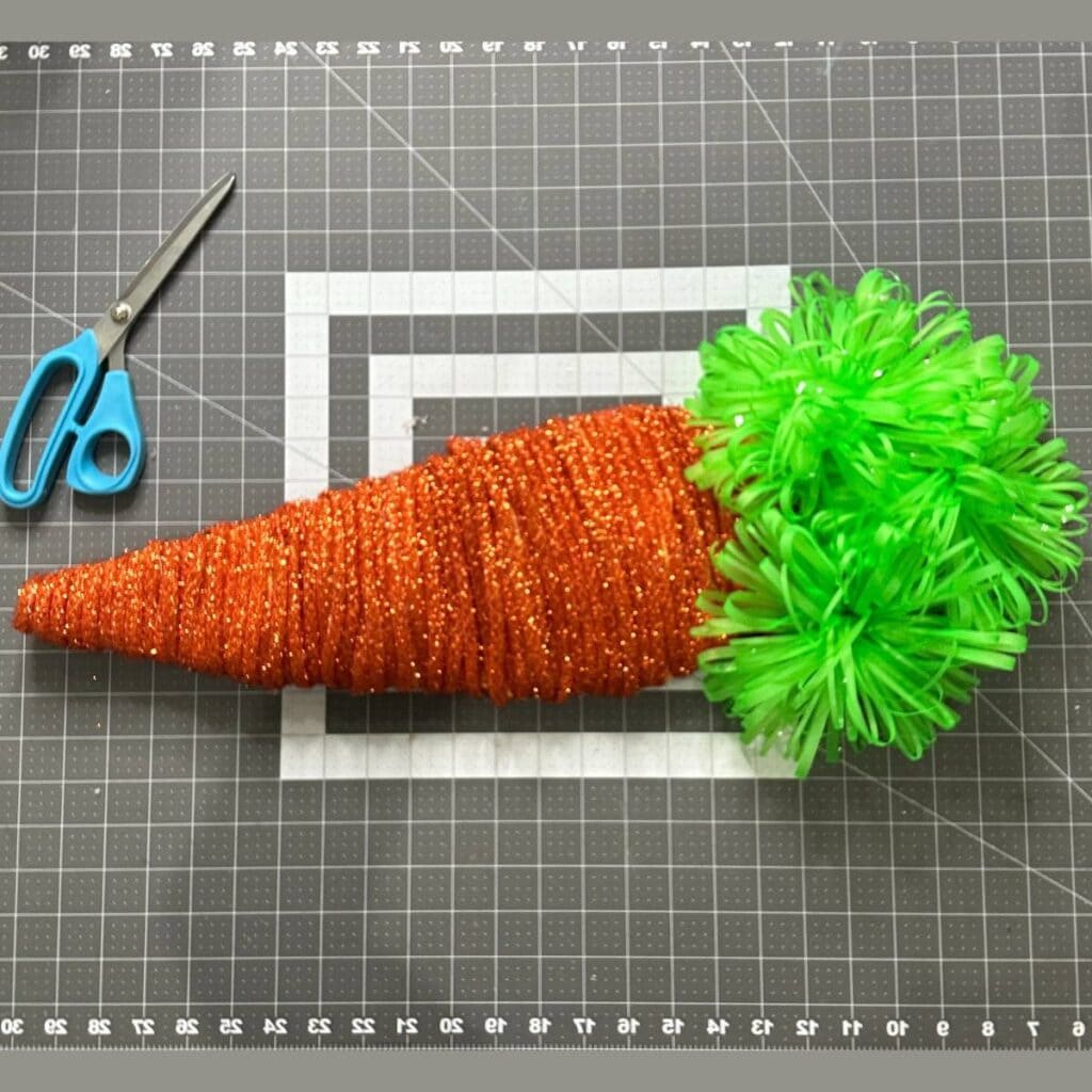 diy easter carrot made with carrot form from dollar tree, copper tinsel tubing, and green bows