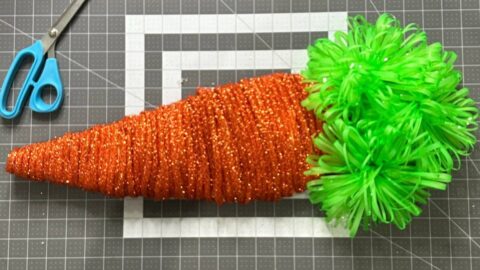 diy easter carrot made with carrot form from dollar tree, copper tinsel tubing, and green bows