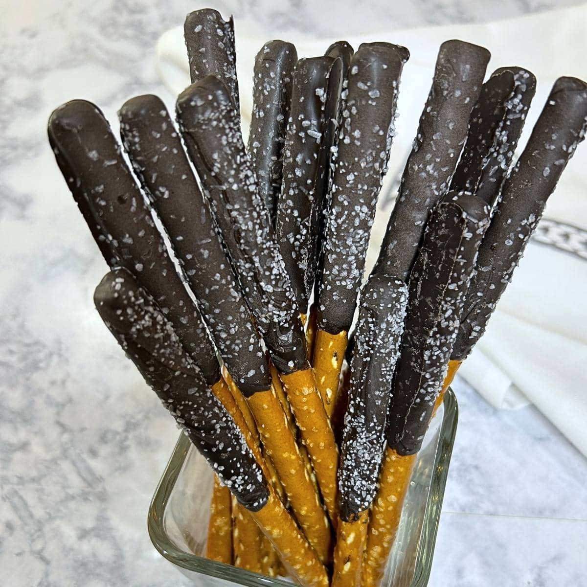 pretzel rods dipped with dark chocolate with sea salt sprinkles