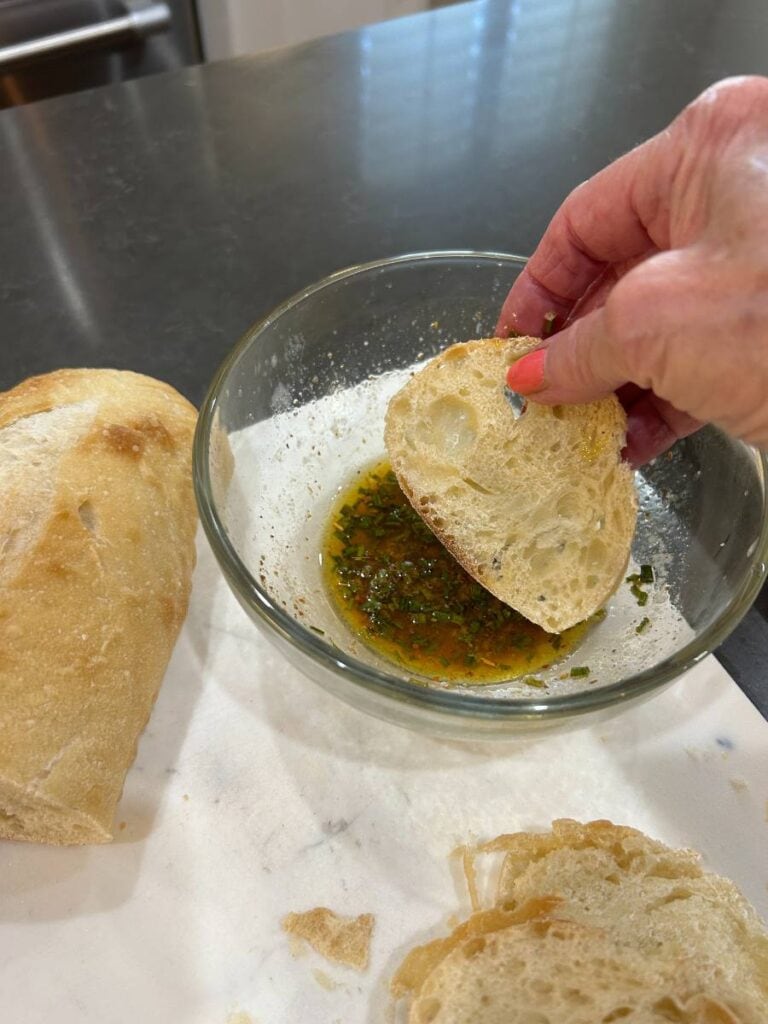drip bread slices into a mixture of olive oil, melted butter, and spices