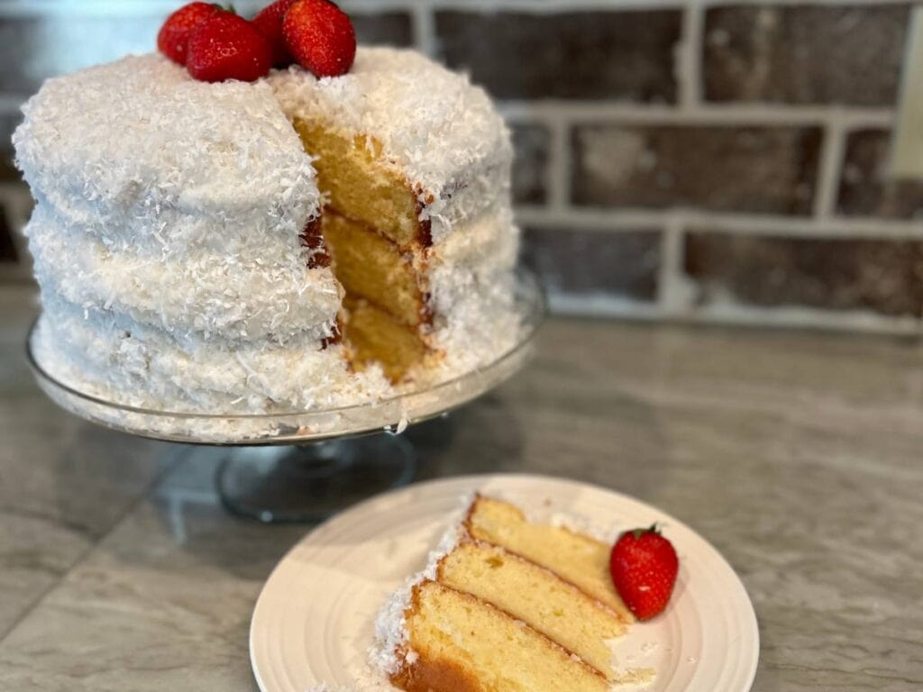 slice of fresh coconut layer, three layers, topped with whole strawberries