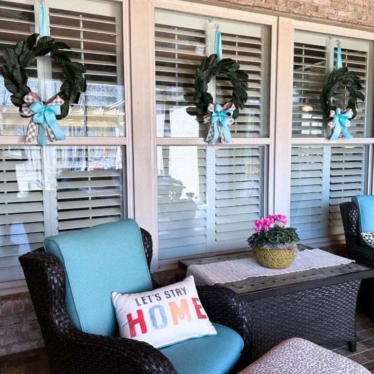 back porch Magnolia wreaths updated with new bows for spring to match chair cushions