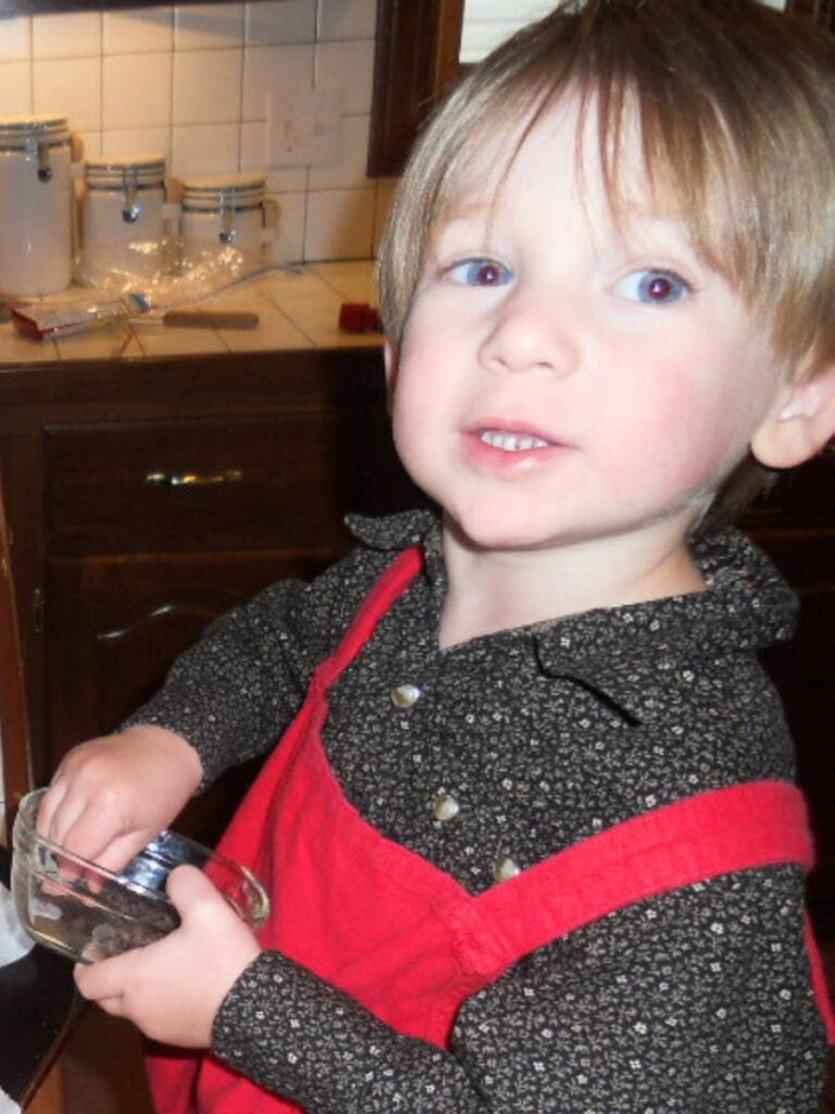 matt wearing a red apron making cookies in the kitchen