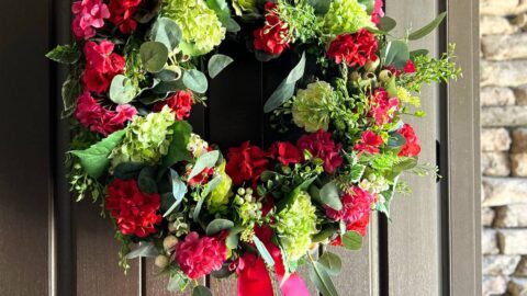 bargain eucalypts wreath turned into a stunning front door wreath with the addition of geranium blooms, hydrangeas and boxwood greenery