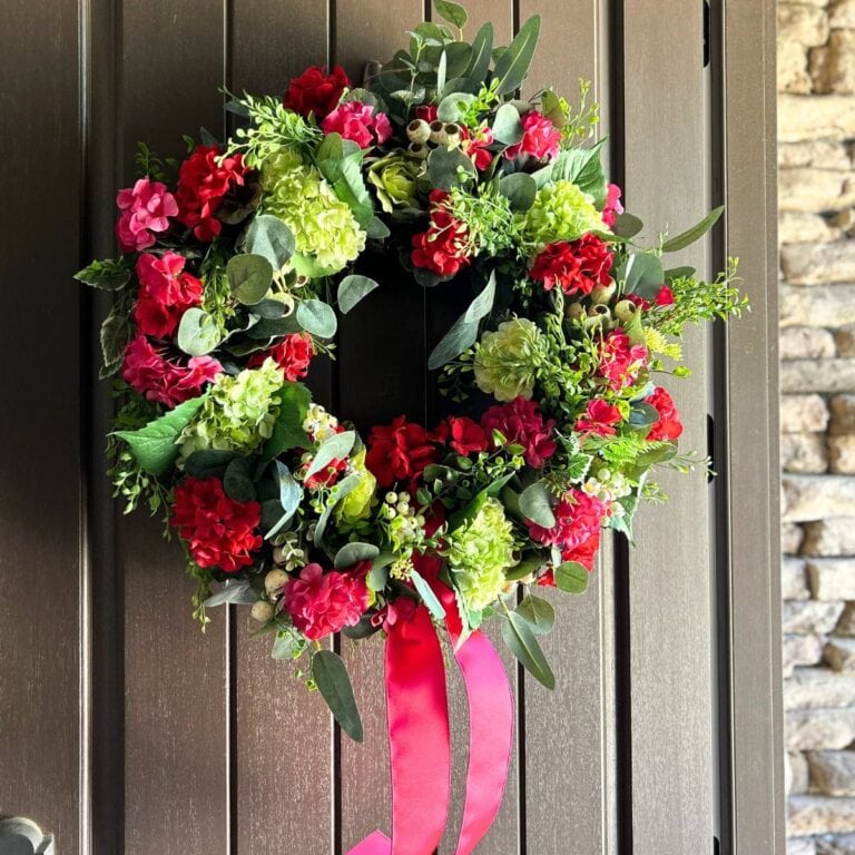 bargain eucalypts wreath turned into a stunning front door wreath with the addition of geranium blooms, hydrangeas and boxwood greenery