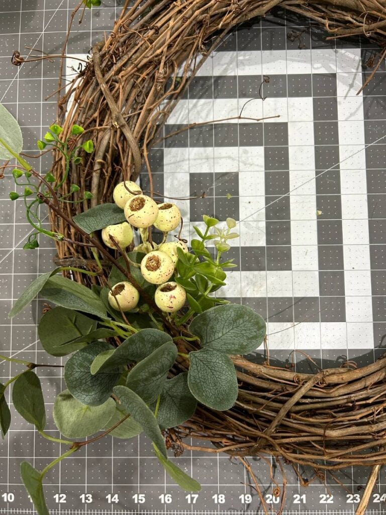 grapevine wreath with pieces of eucalyptus and white berries attached