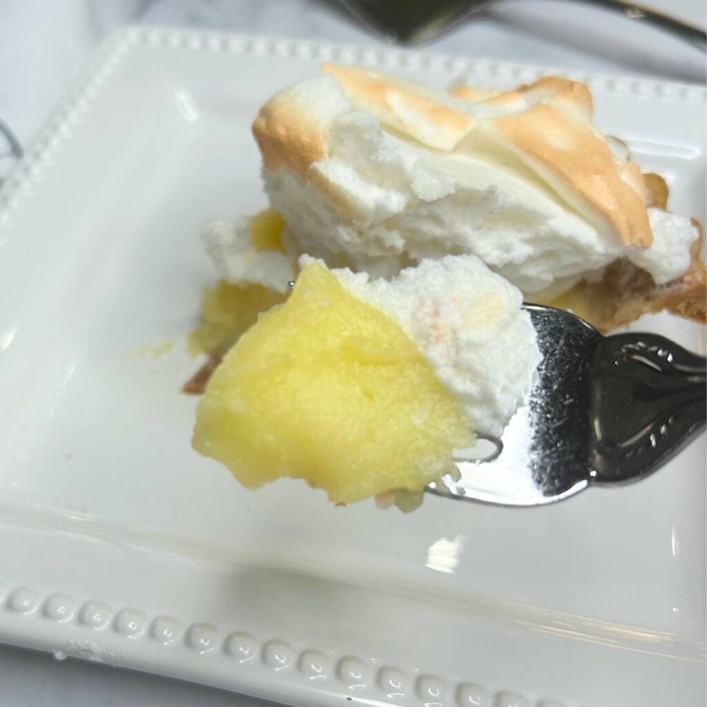 slice of lemon meringue pie with bite on a fork