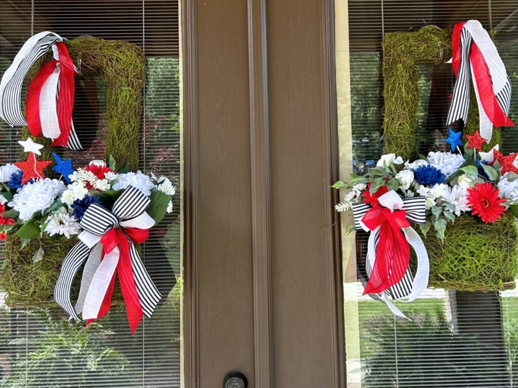 patriotic moss baskets decorated for Memorial Day and 4th of July hanging on double side doors