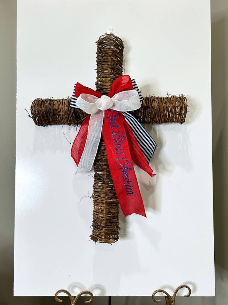 twig cross with patriotic bow on workboard in craft room