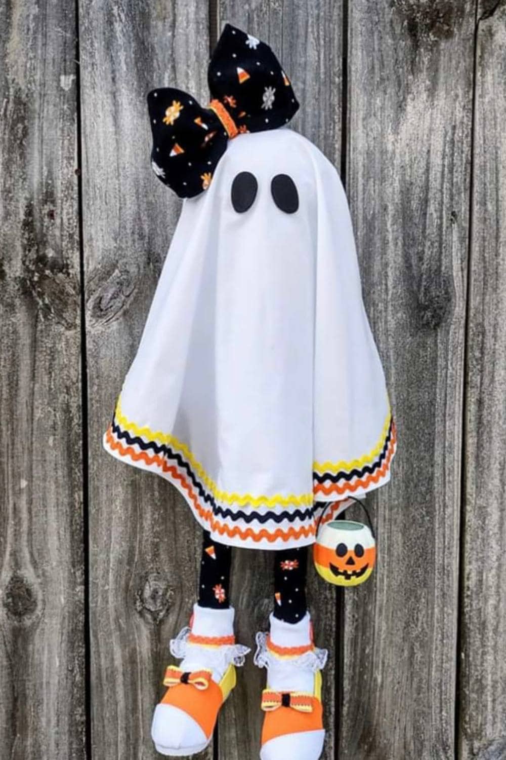 cute ghost wreath attachment with socks and shoes, decorated in orange, yellow, and white