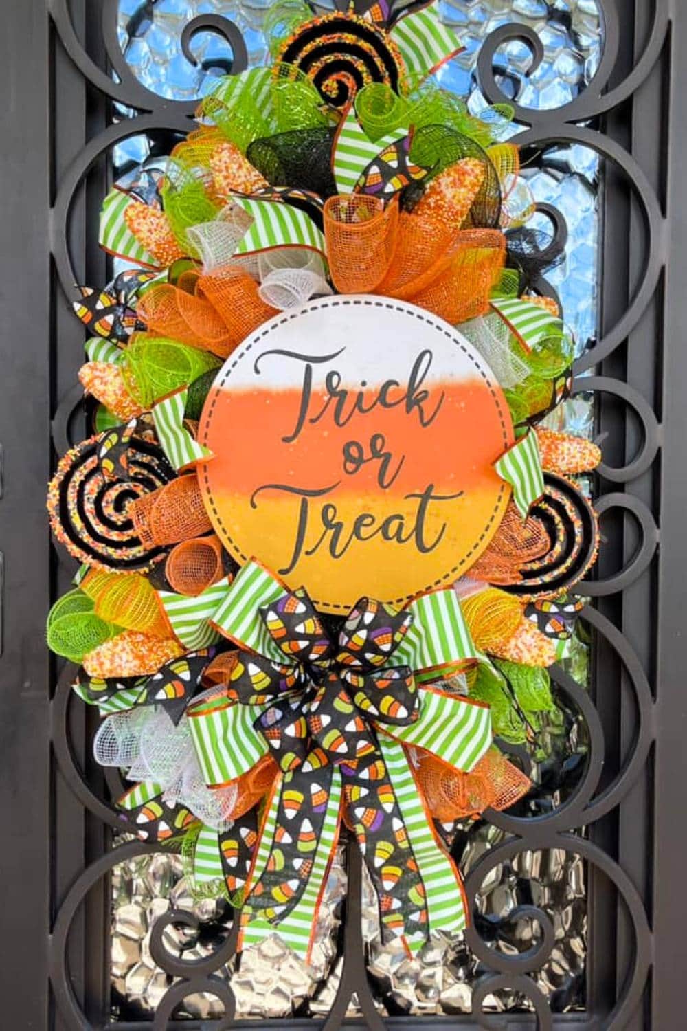 candy corn wreath with trick or treat sign and halloween ribbons