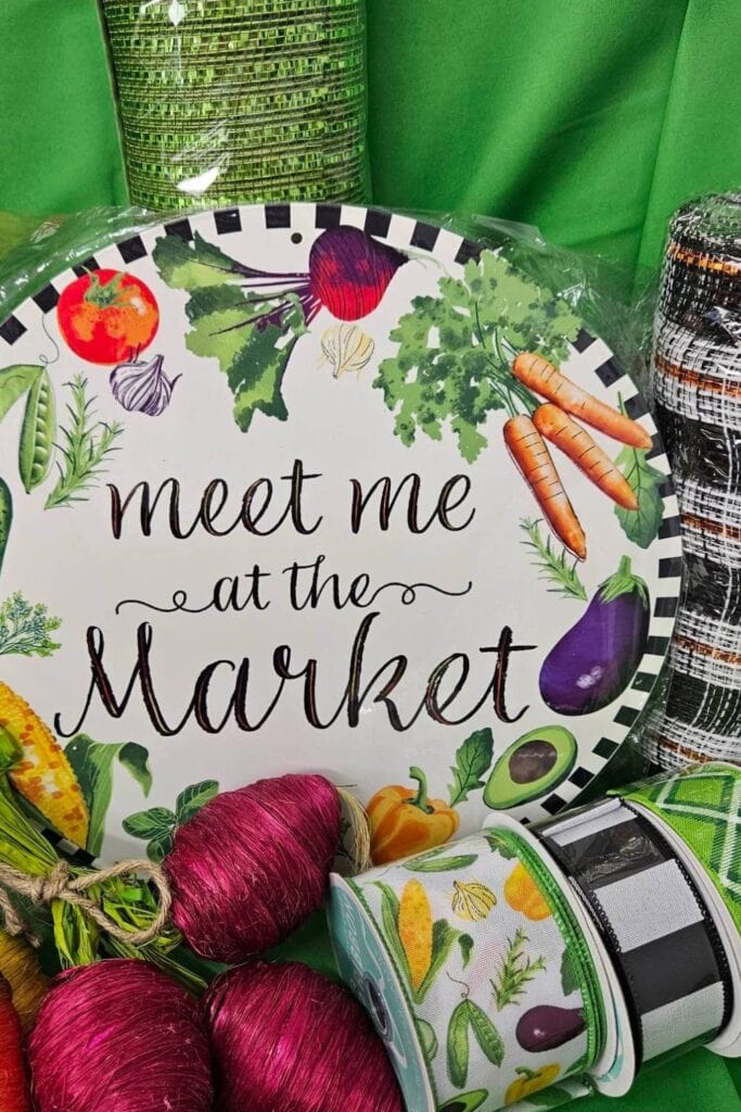 supplies to make a deco mesh wreath with veggies and meet me at the market sign