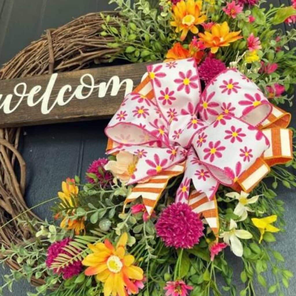 grapevine wreath with peach blooms, daisies and a pretty bow