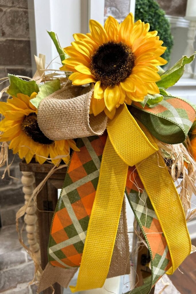 close up of sunflower, burlap ribbon, fall plaid ribbon and bright yellow ribbon