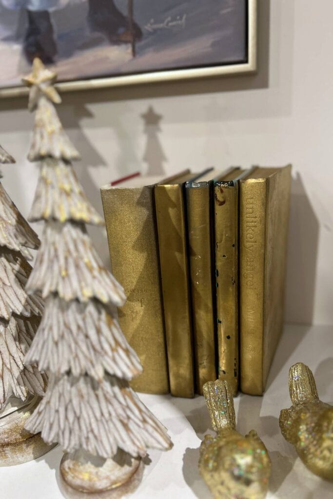 books that have been sprayed gold and used on a bookcase to display