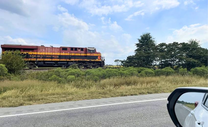 a train running parallel with the highway in the delta