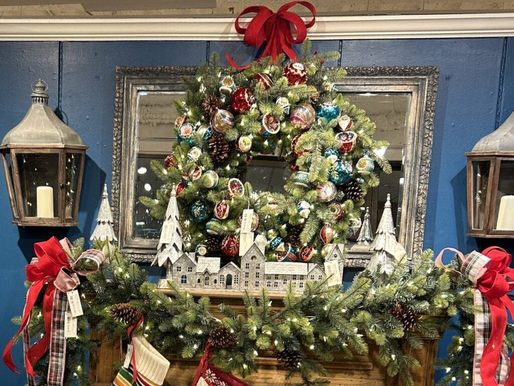 mantel decorated with a pine garland, and wreath covered with vintage glass ornaments, reflectors, finials, and kismets