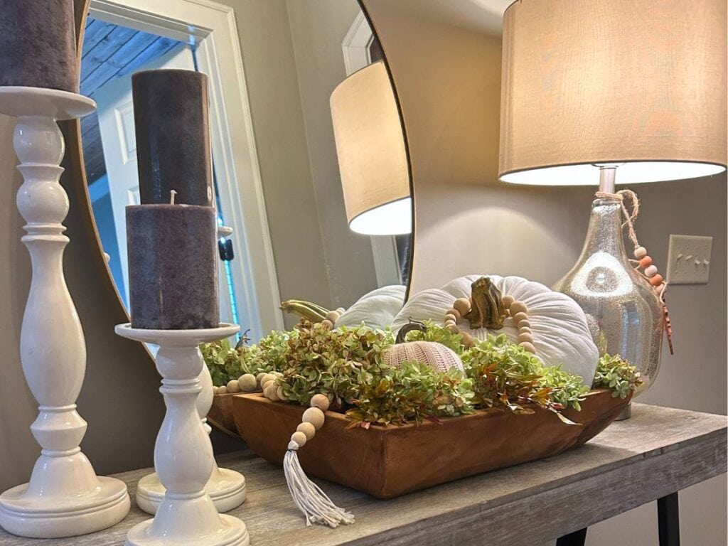 fall arrangement using a fabric pumpkin in a wooden bowl and wood bead garland and hydrangeas