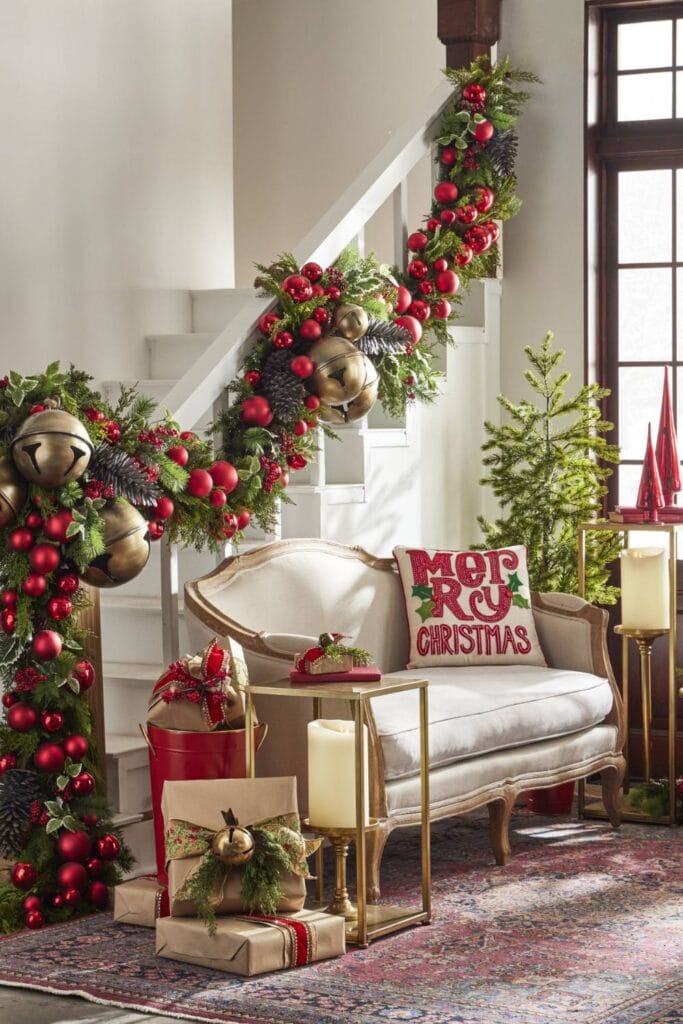 classic evergreen garland decorated with red matte and shiny balls, huge gold jingle bells, and pinecones