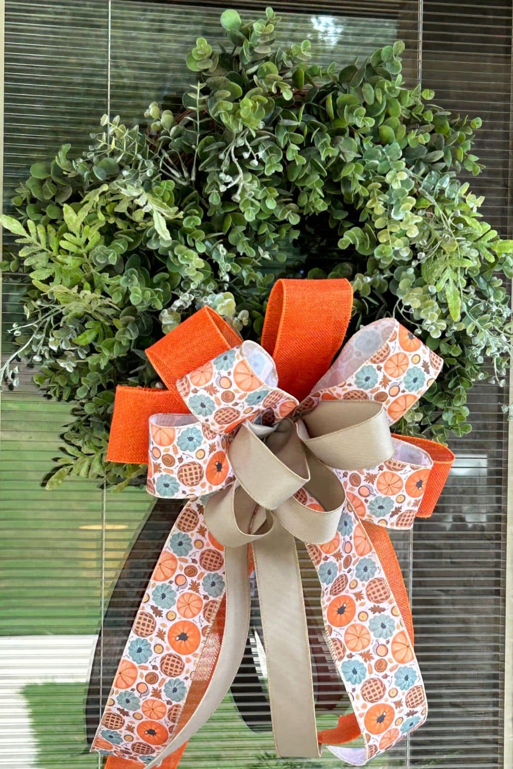 fall bow for a boxwood wreath in orange, pumpkin print and taupe ribbons