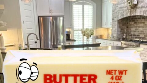 a stick of butter with kitchen in the background